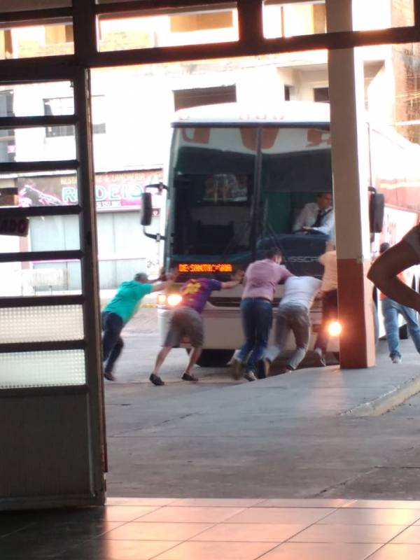 Ônibus da Expresso São Pedro sem ré é empurrado por populares na Rodoviária de Santiago